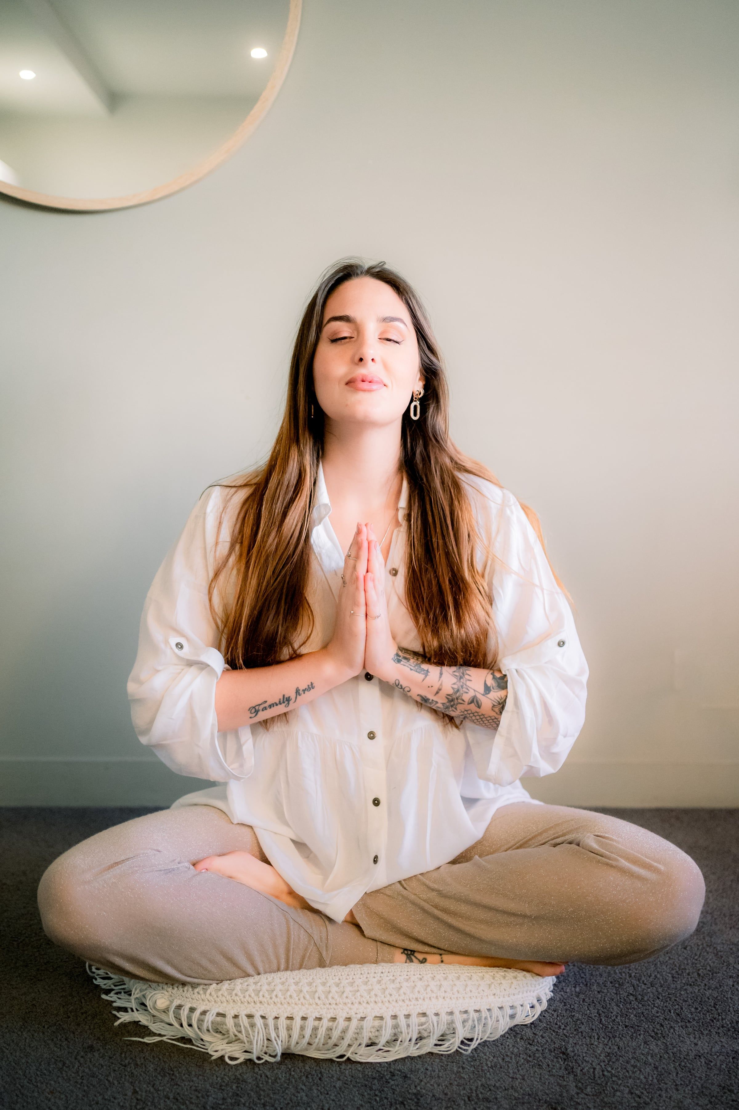 Raffaela in meditazione, a occhi chiusi, accanto a uno specchio